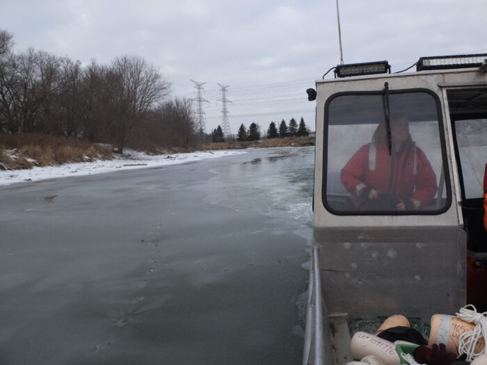 A scientist driving a boat to collect eDNA samples.